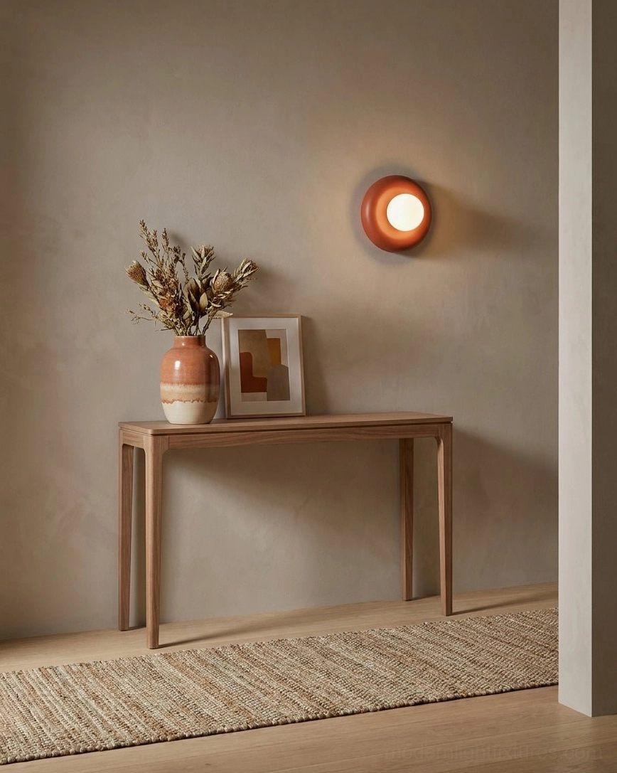 Terracotta Pop wall sconce glowing soft warm light on hallway console table with earthy bohemian decor