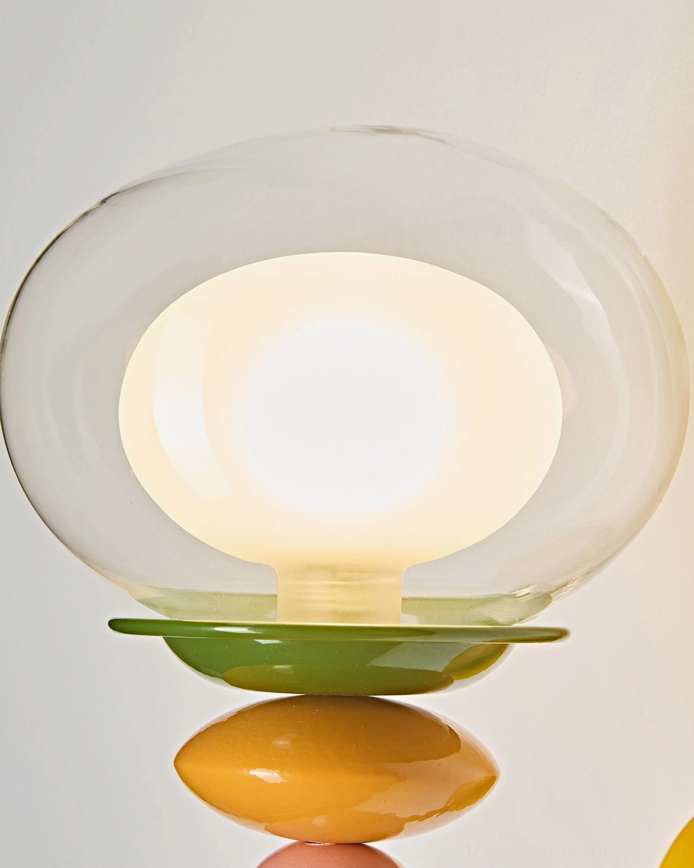 Popella wall sconce flat lay product shot showing yellow backplate, stacked beads, and glass globe components