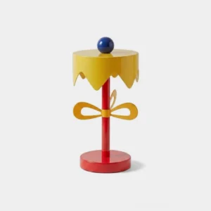 Poppette Memphis table lamp with yellow scalloped shade, blue ball finial, red stem, and metal bow detail - front studio view