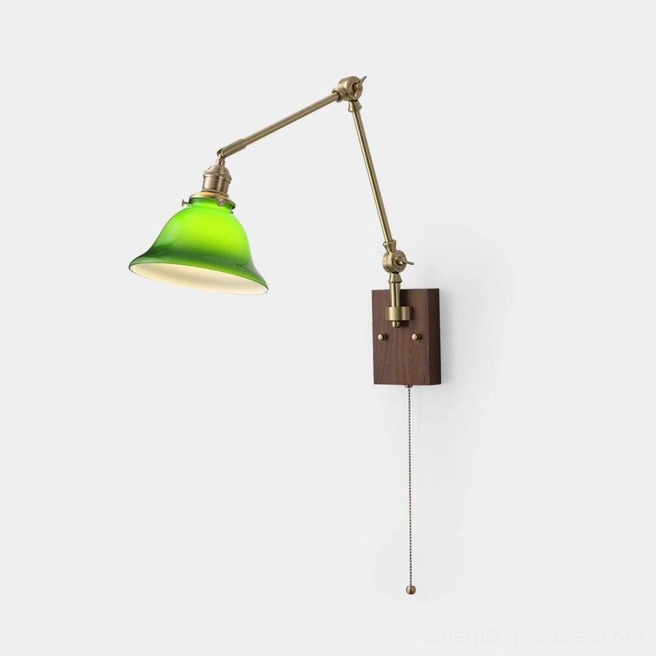 Premium brass swing arm wall sconce with dome-shaped green glass shade, showing craftsmanship and timeless vintage aesthetic design