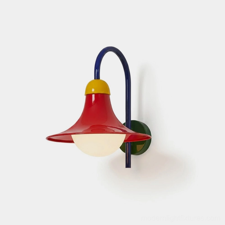 Primora colorblock wall sconce frontal studio view showing blue arched arm, red flared shade, yellow accent cap, and green backplate with opal globe diffuser