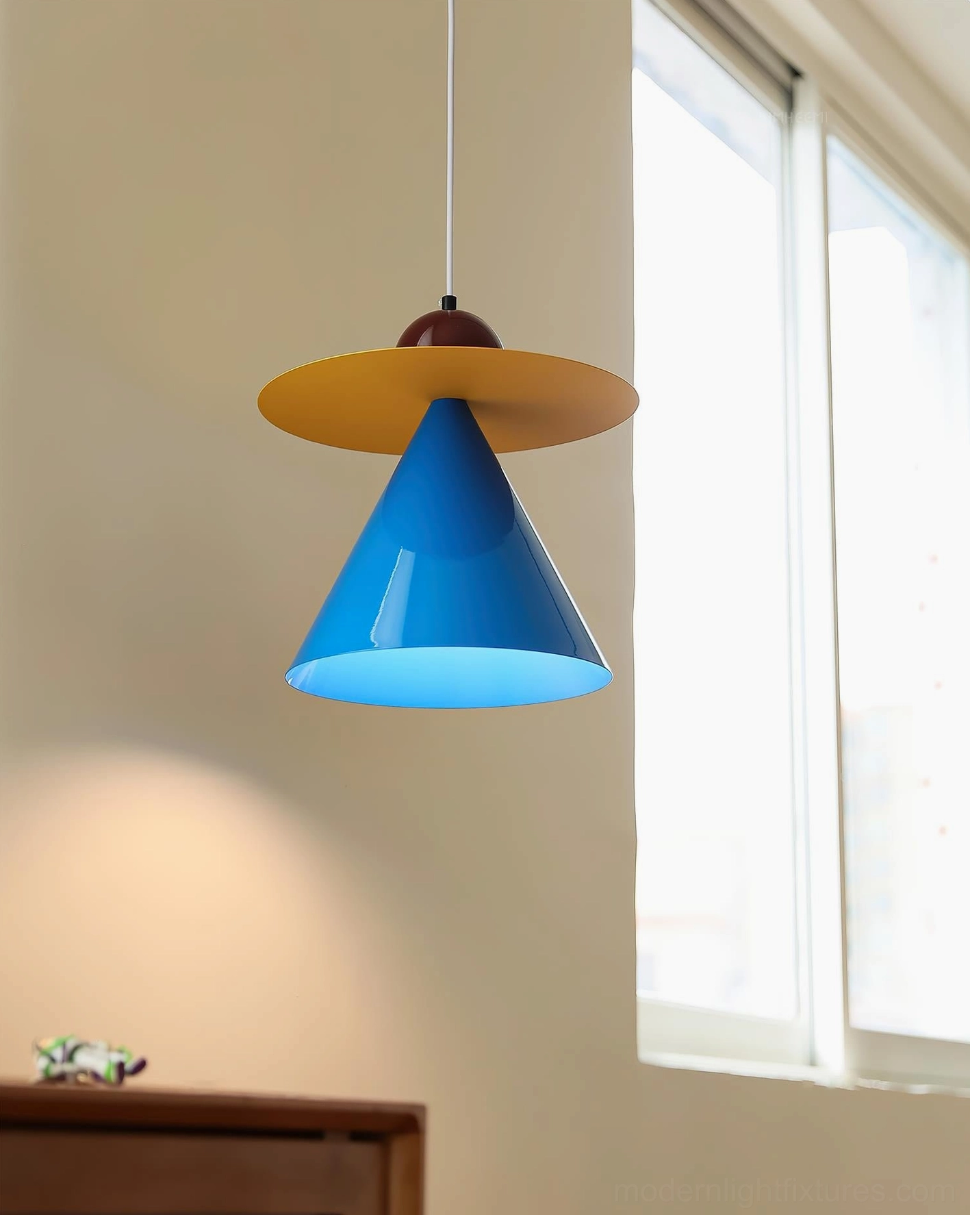 Contemporary color-block pendant light side angle view with natural window lighting