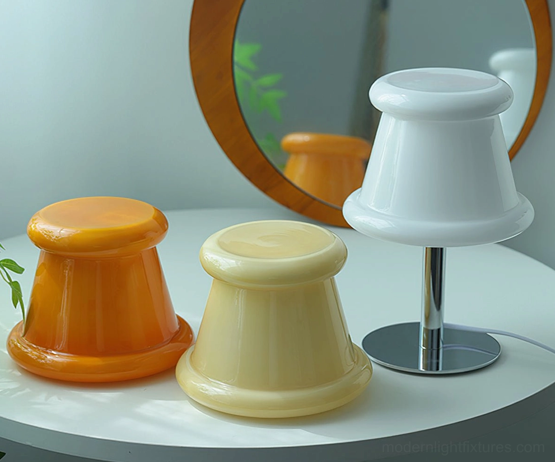 Three pudding table lamps displaying available color options amber orange, cream beige, and white frosted with chrome stands