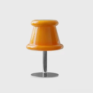Pudding glass table lamp with amber orange rounded shade and polished chrome stem and base, front studio view on white background