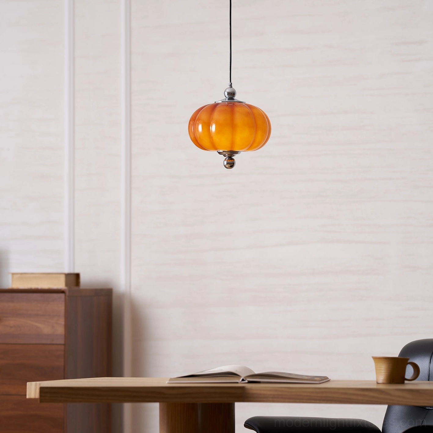 Mini amber orange handblown pumpkin glass pendant lamp in modern dining space