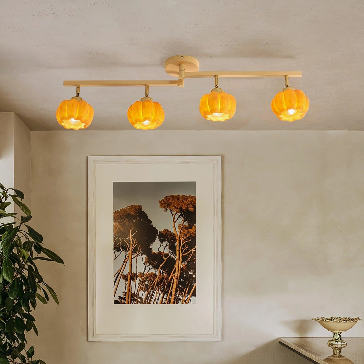 Pumpkin glass ceiling light fixture showing warm amber light diffusion, branch framework silhouette, ambient illumination detail