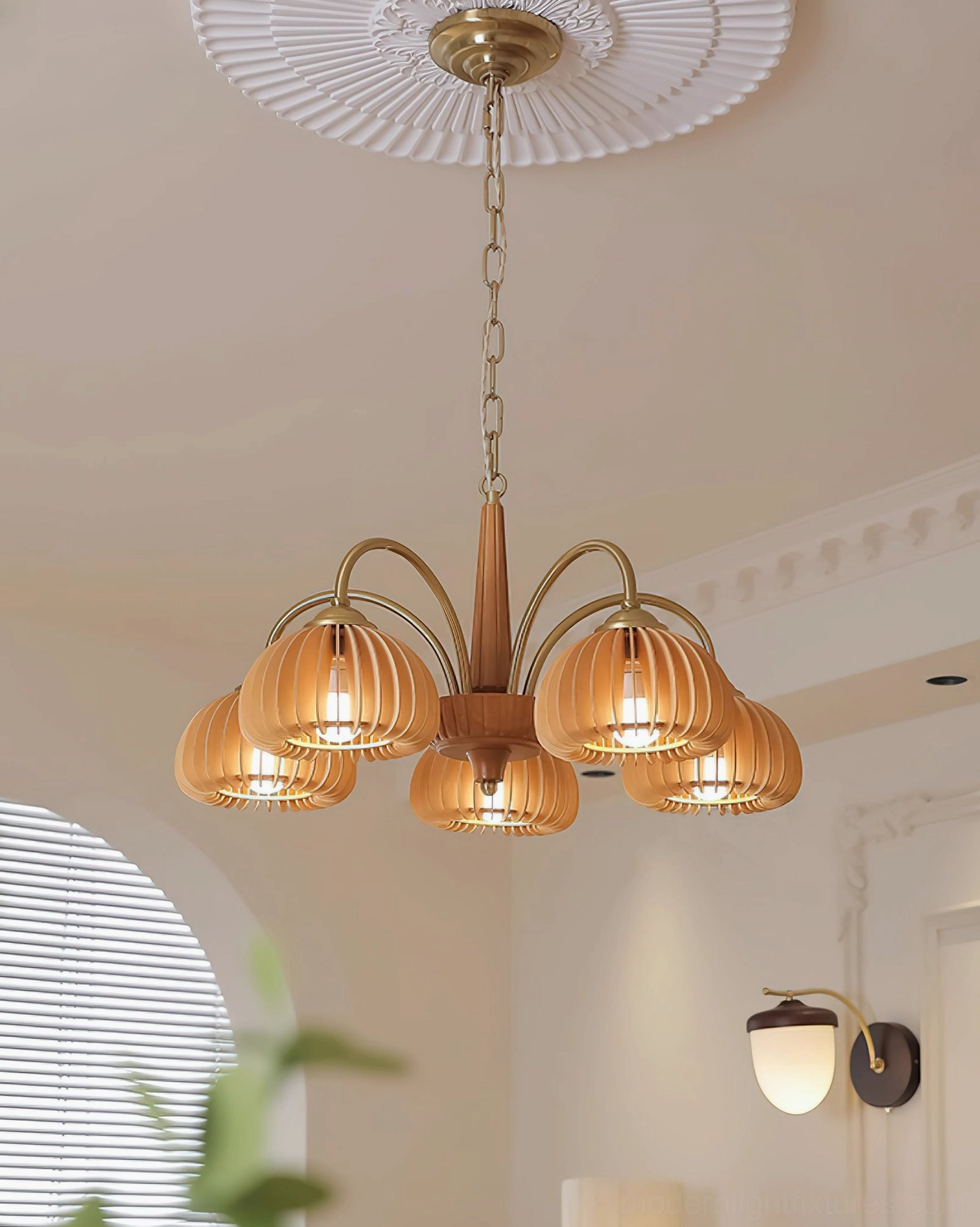 Pumpkin ribbed glass chandelier hanging from adjustable chain in neutral interior setting