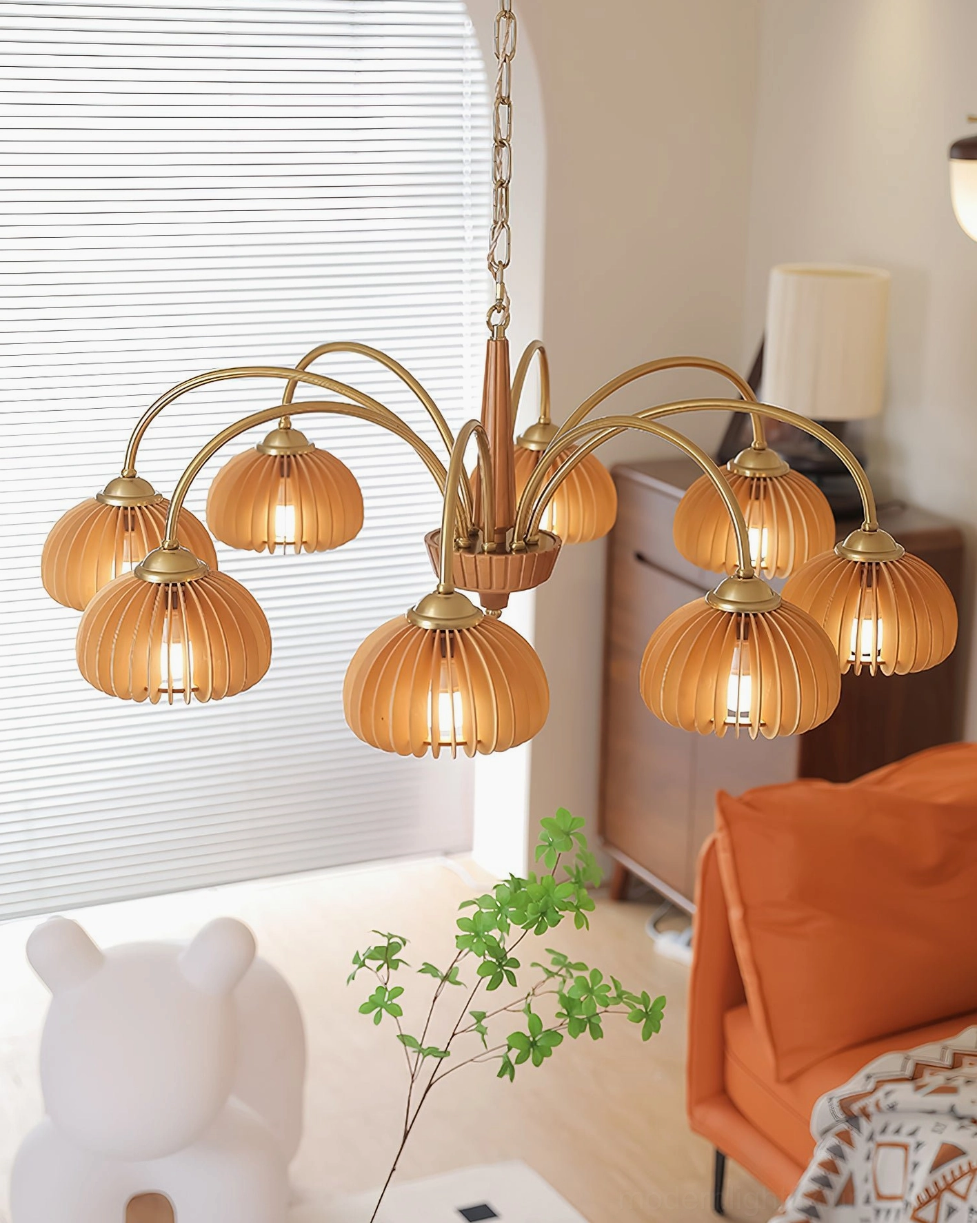 Lit pumpkin chandelier in vintage family living room with orange sofa and warm ambient lighting