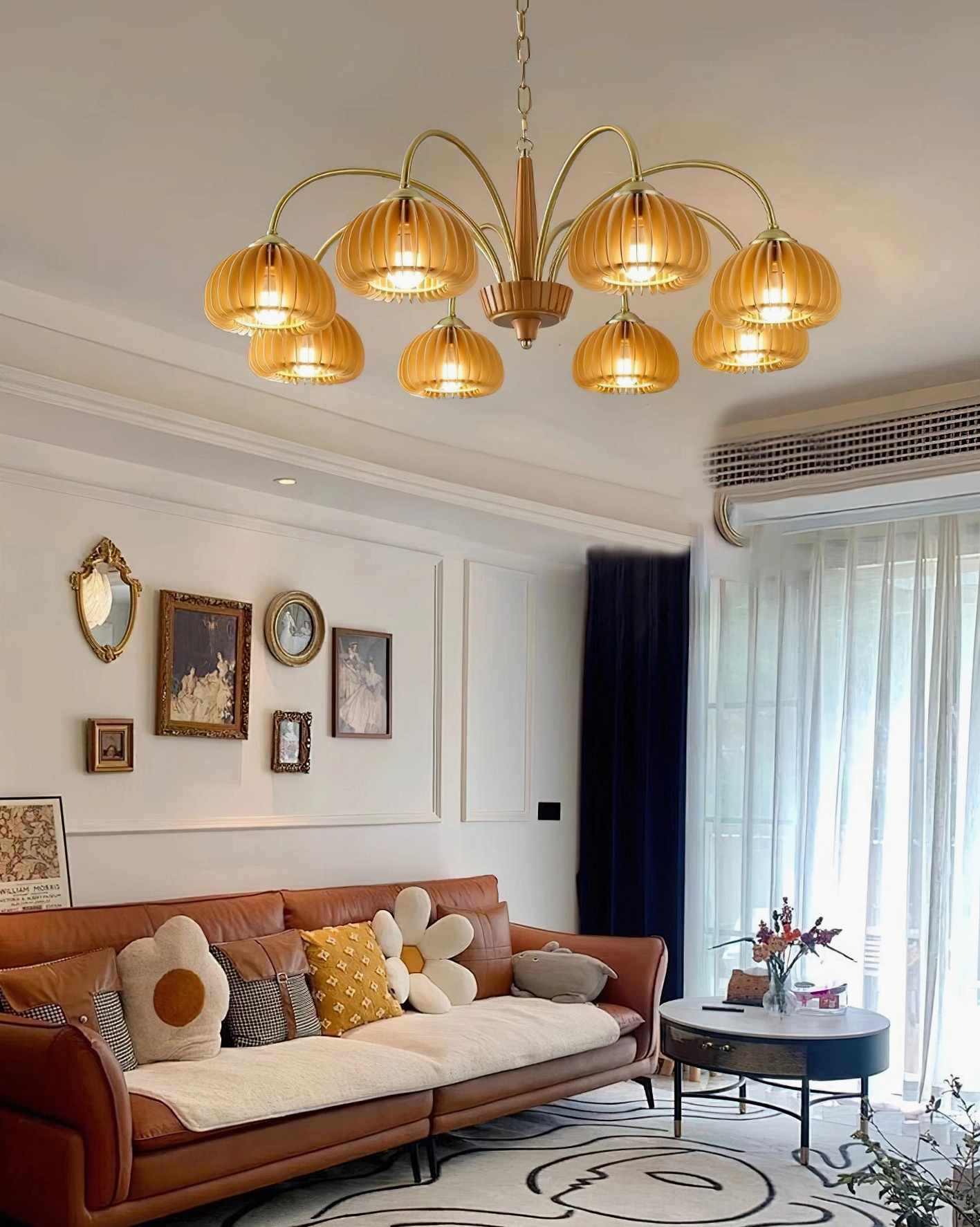 Pumpkin ribbed glass chandelier in warm mid-century living room with brass hardware and golden shades