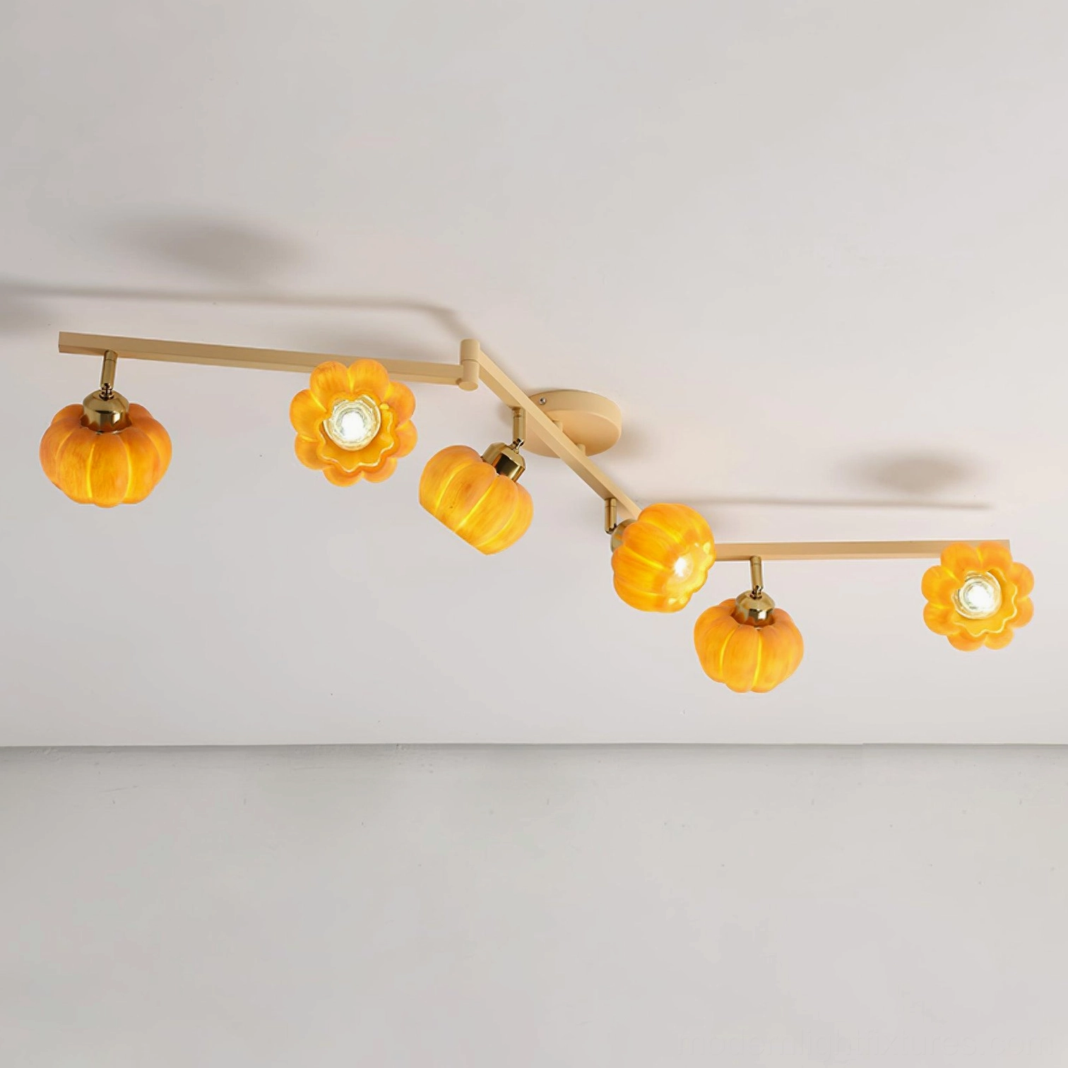 Pumpkin ceiling light close-up showing hand-crafted amber glass shades, resin construction, warm color tone