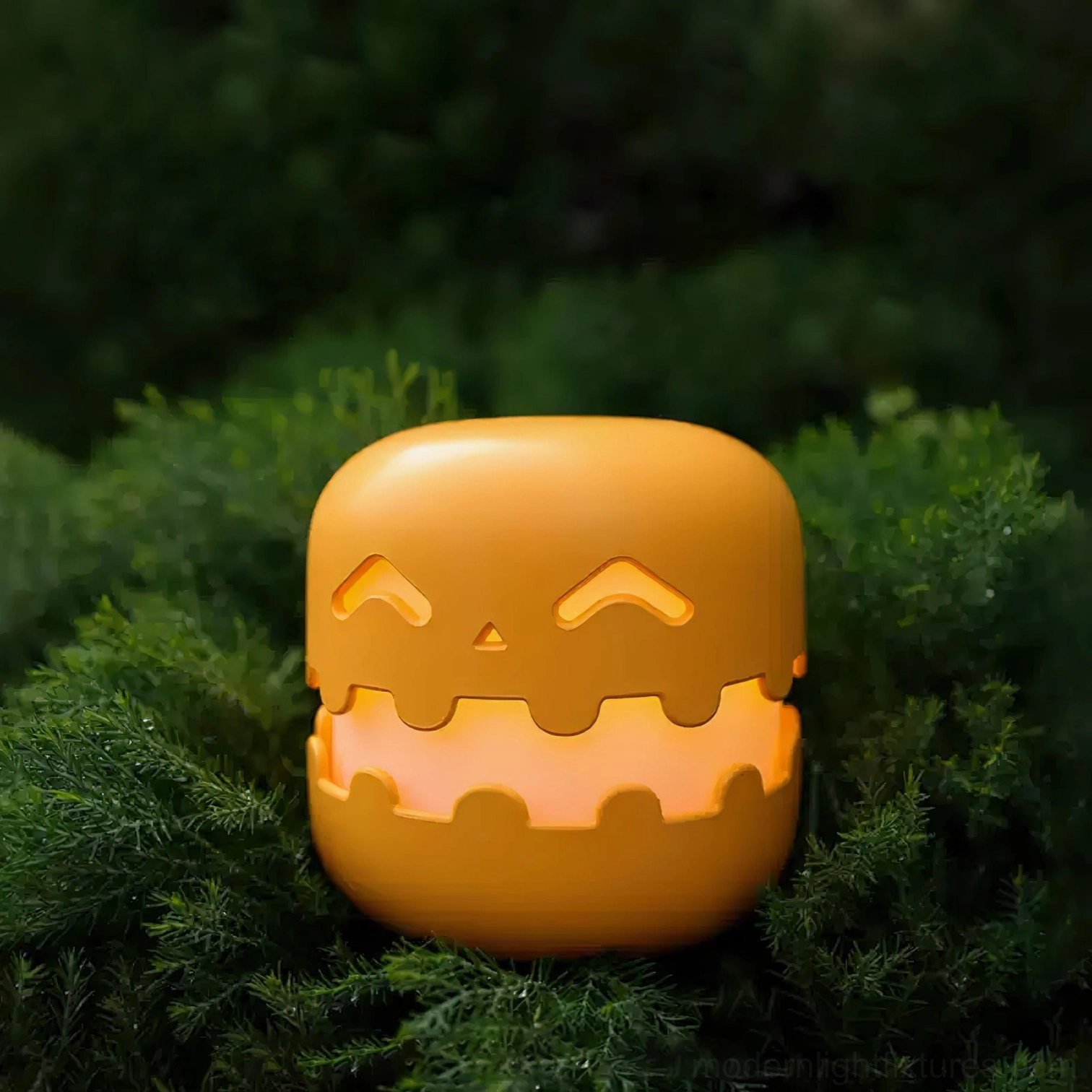Pumpkin table lamp with carved face design placed among green plant foliage