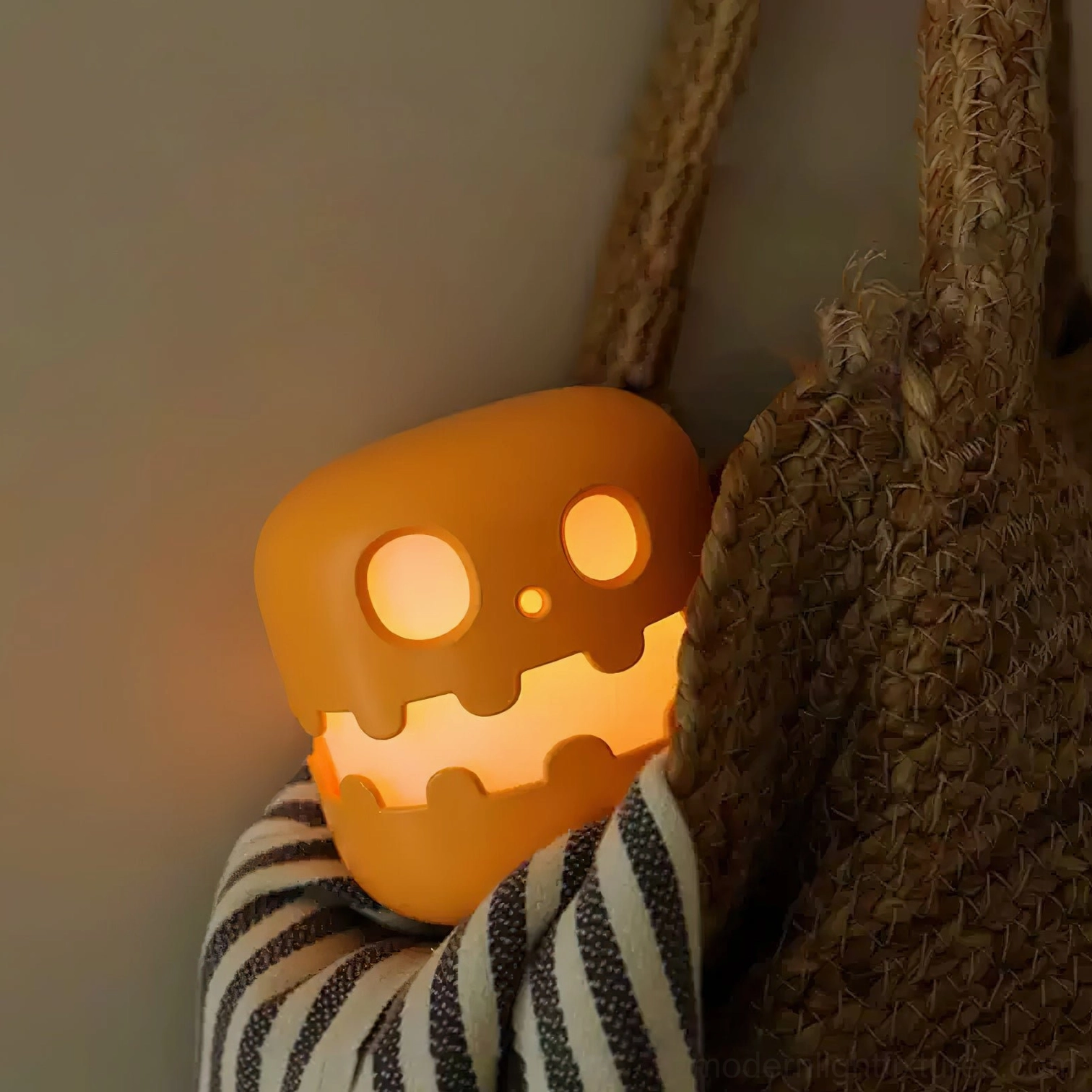 Pumpkin accent lamp with warm glow displayed beside woven storage bag