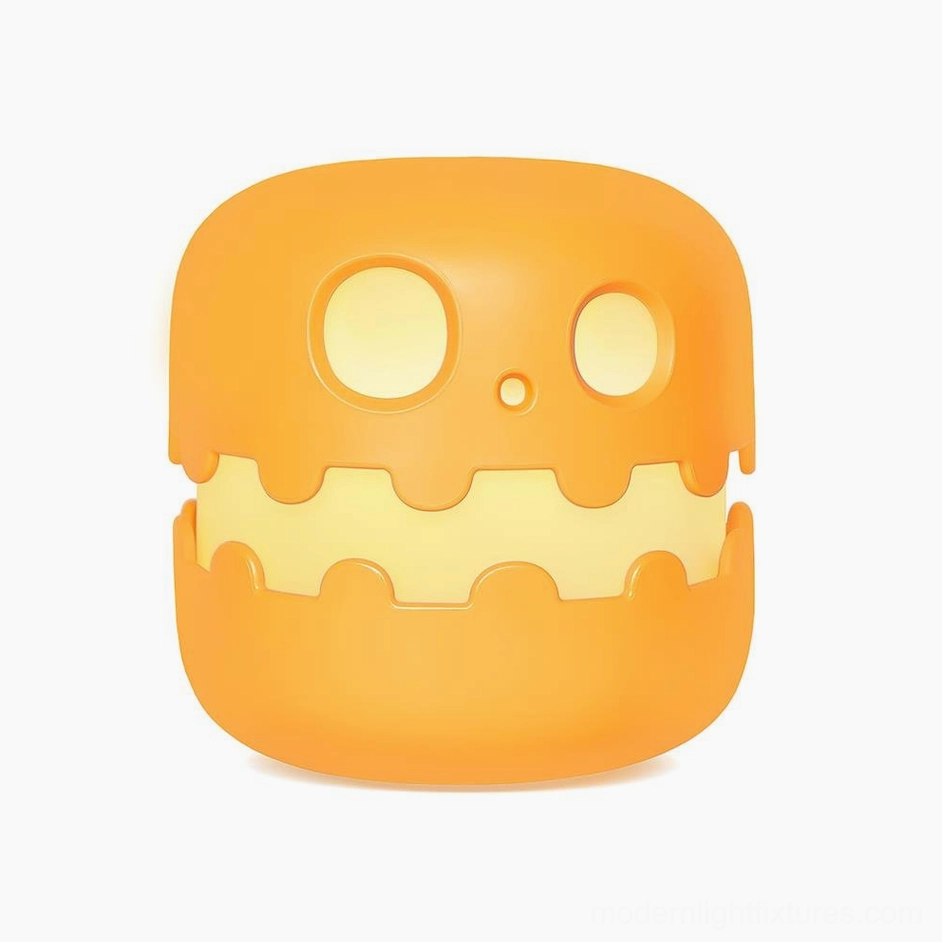 Pumpkin table lamp Model B with squinting playful expression and USB charging