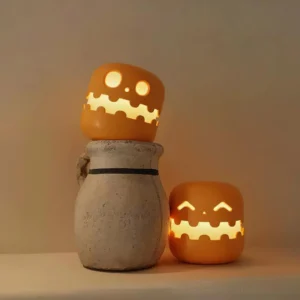 Two pumpkin accent lamps with warm glow displayed on desktop, indoor home setting