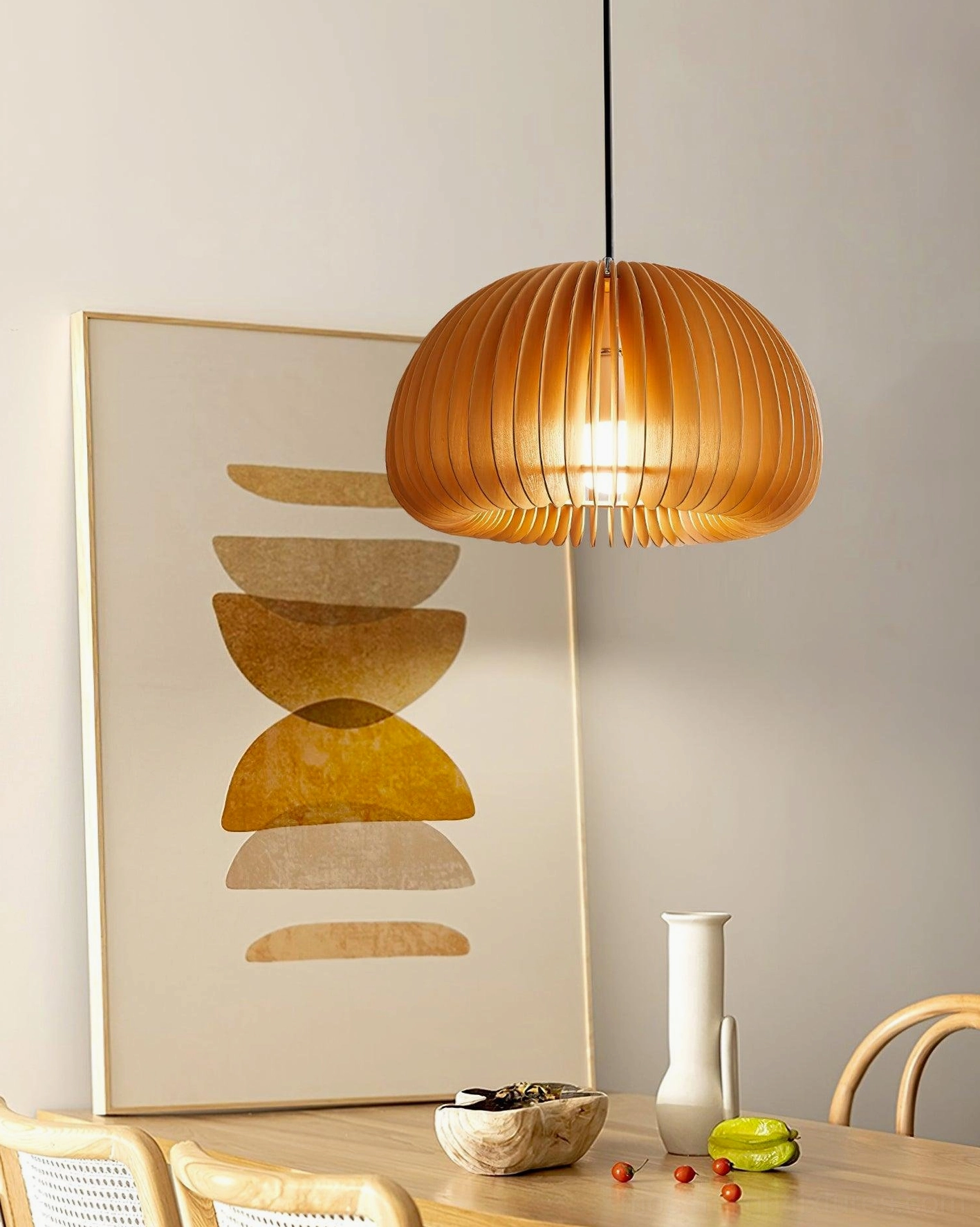 Round pumpkin-shaped wood pendant lamp side view in residential dining room with natural finish