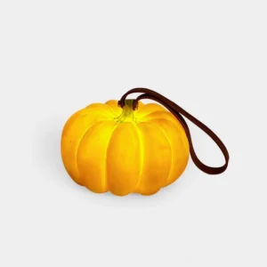 Warm glow pumpkin portable table lamp with ribbed texture and brown leather hanging strap, studio front view