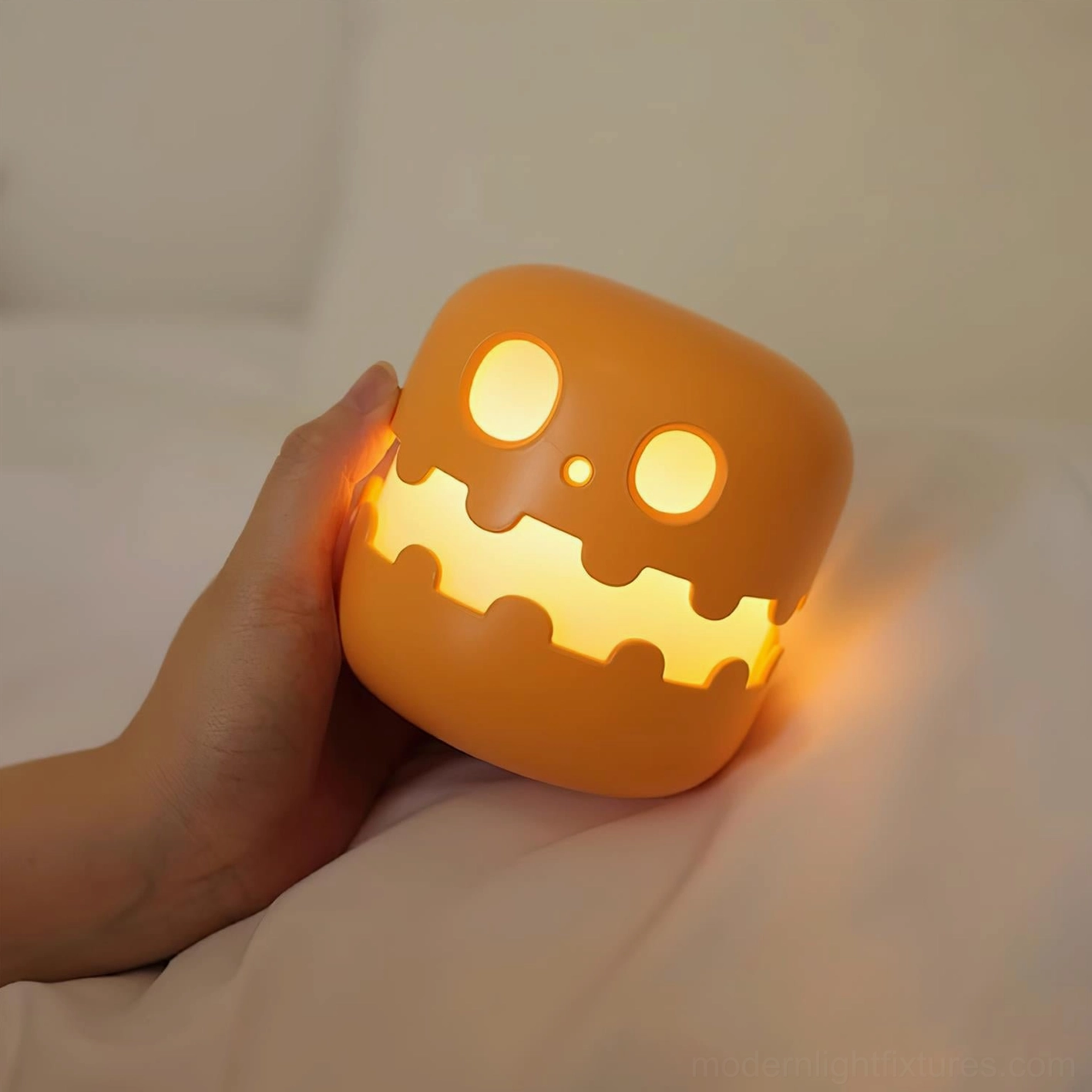 Pumpkin night light on bedroom bedside with warm ambient light on soft bedding