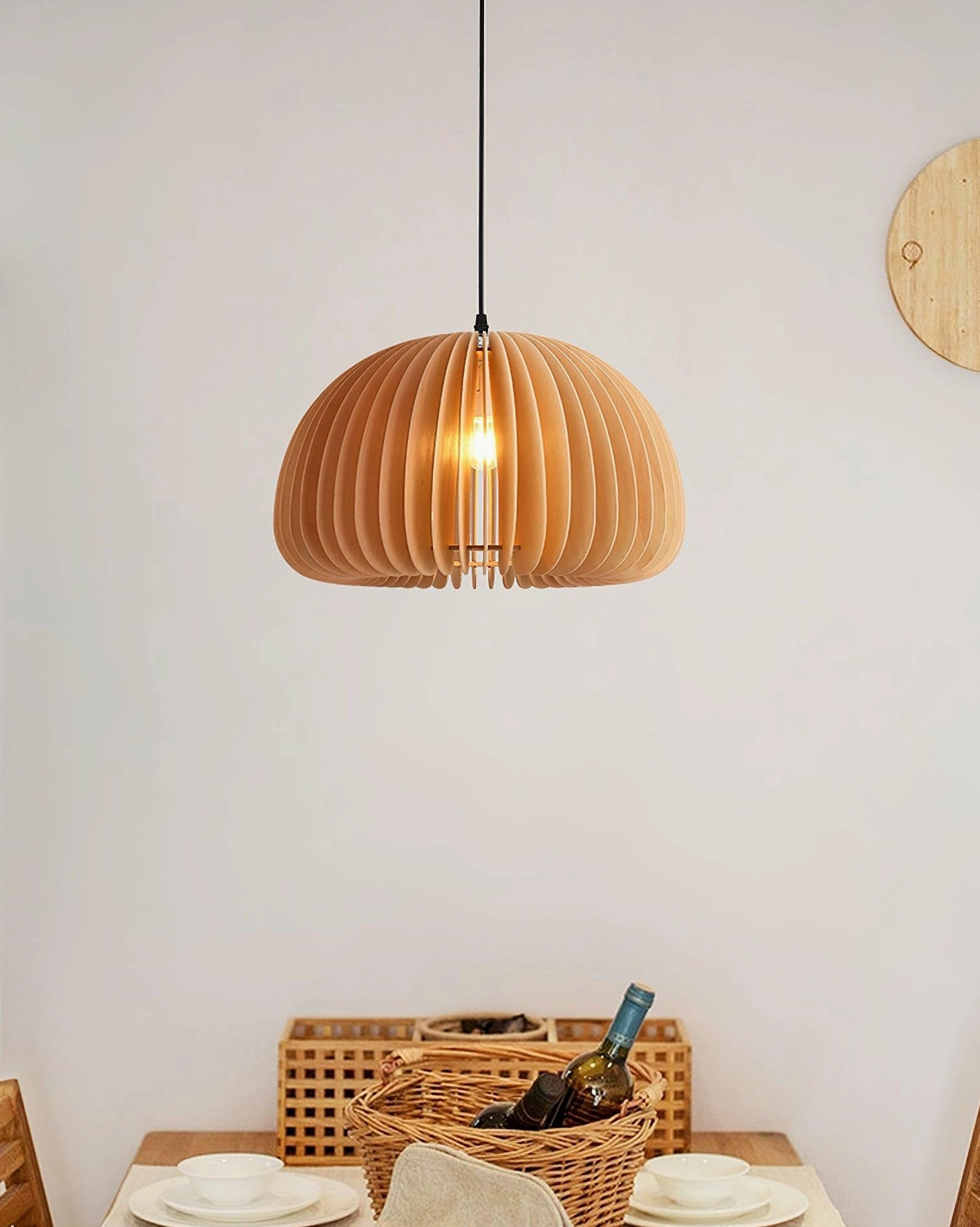 Wooden pumpkin pendant lamp hanging in dining area with natural light wood finish and exposed filament bulb
