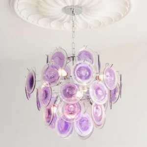 Purple glass disc chandelier mounted on white decorative ceiling medallion, warm interior lighting, overhead installed view
