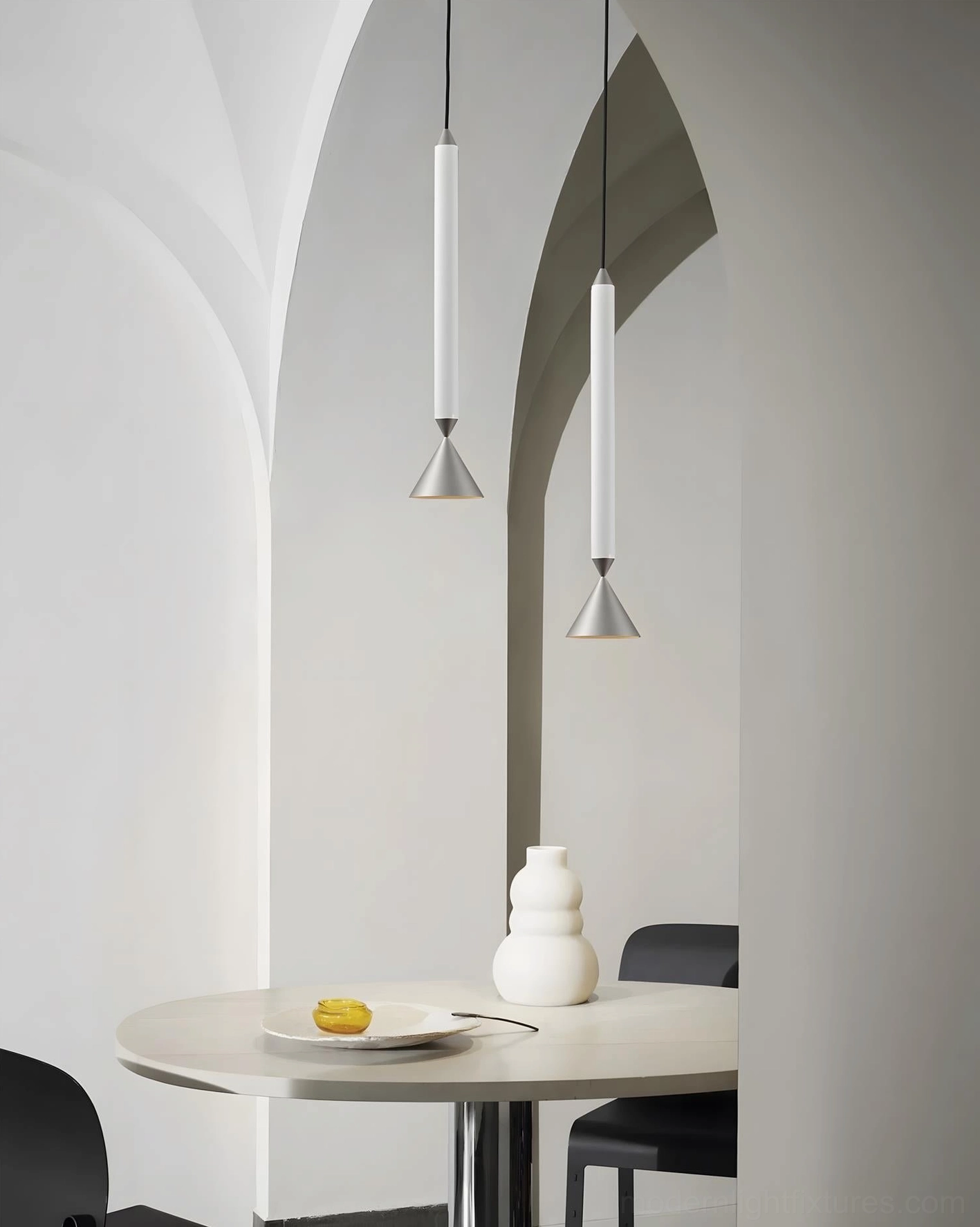 Two-tone Pylon pendant lights suspended above modern dining table with arched walls, contemporary minimalist interior design