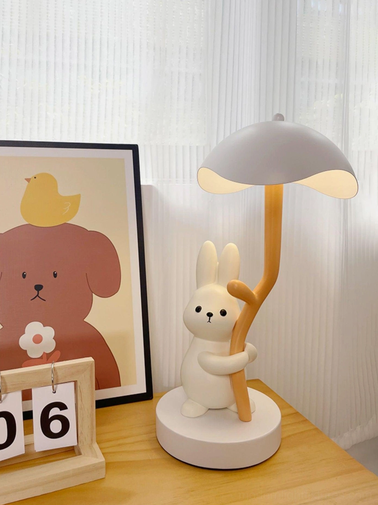 Rabbit hug table lamp with gray shade three-quarter left view on wooden desk