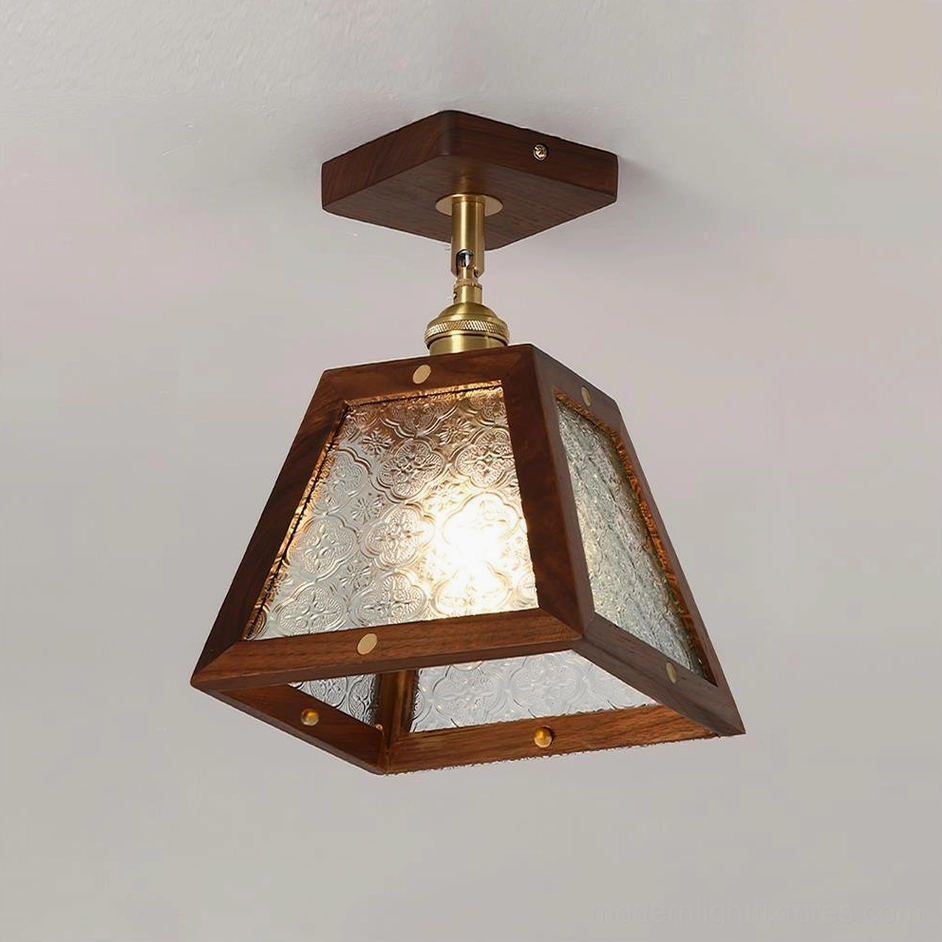 Radia stained glass ceiling fixture front three-quarter view with clear textured glass, glowing internal bulb, and dark wood frame