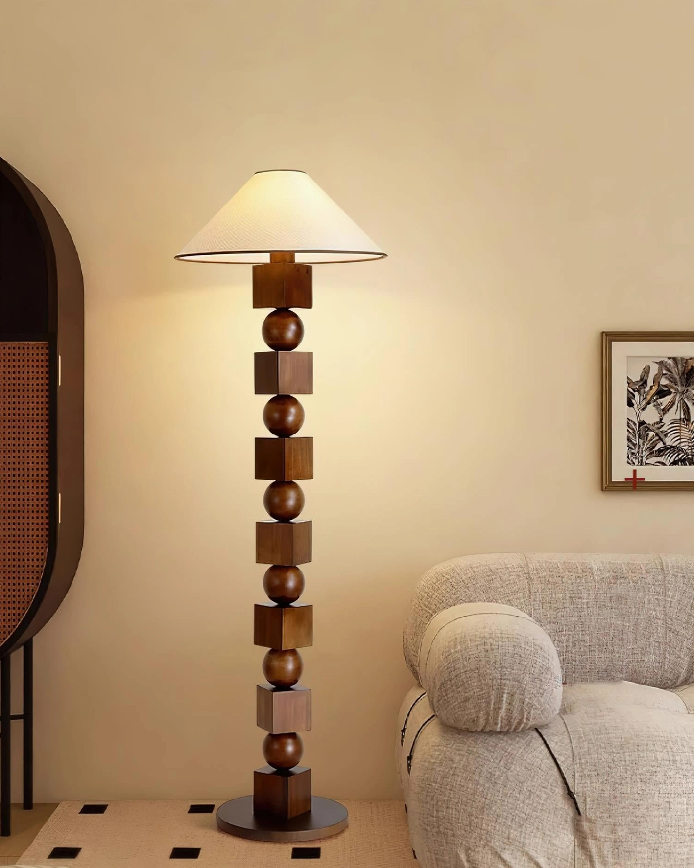 Vintage-inspired sculptural wooden floor lamp in deep brown walnut finish positioned in modern living room with sofa and wall art, three-quarter perspective view