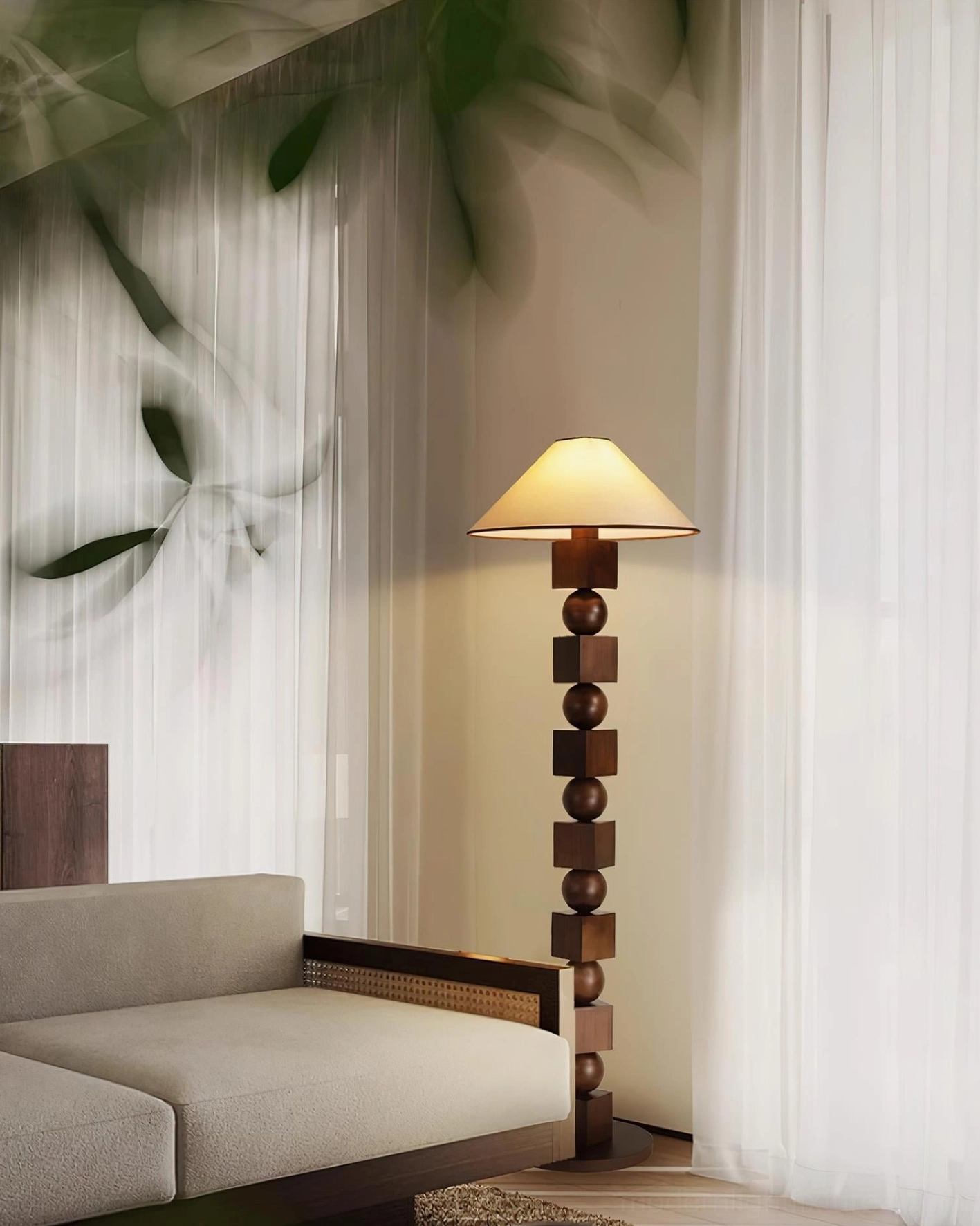 Wooden geometric floor lamp in side-front view positioned in Japandi style living room with sheer curtains, light gray sofa and decorative green leaf plants