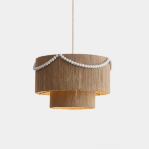 Raffine natural jute drum pendant lamp with white beaded garland, front close-up view on studio white backdrop