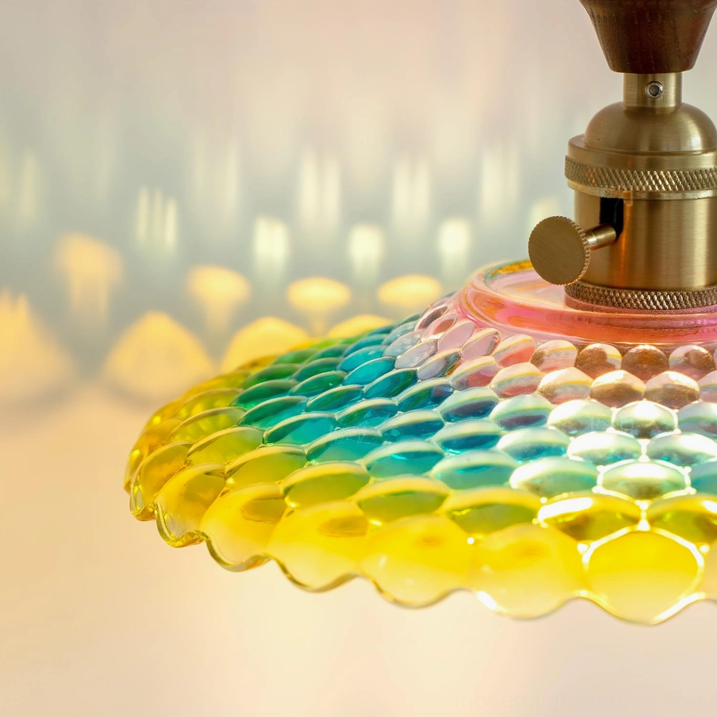 Close-up of Rainbowa pendant fixture showing brass socket and honeycomb textured hand-blown glass detail