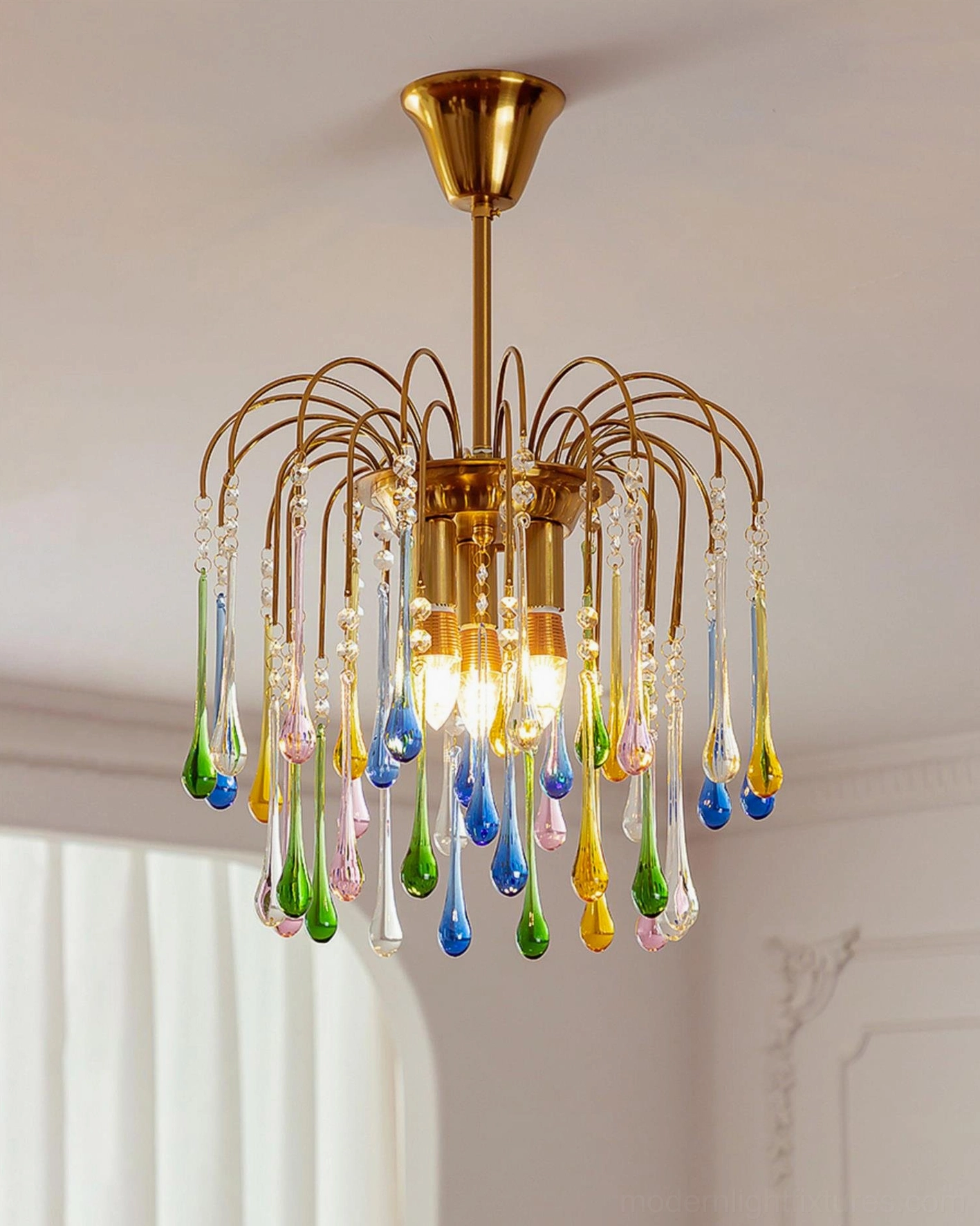 Rainlight crystal teardrop chandelier close-up three-quarter view showing vibrant colored glass and polished brass