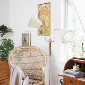 Ramira vintage floor lamp illuminated in bohemian living room setting with warm glowing light, brass and wood construction visible