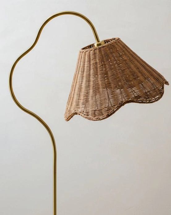 Close-up side view of Carmelle rattan floor lamp showing curved metal frame and scalloped woven rattan shade detail