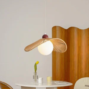 Natural rattan pendant light installed above round dining table in boho minimalist dining room with fluted wooden screen