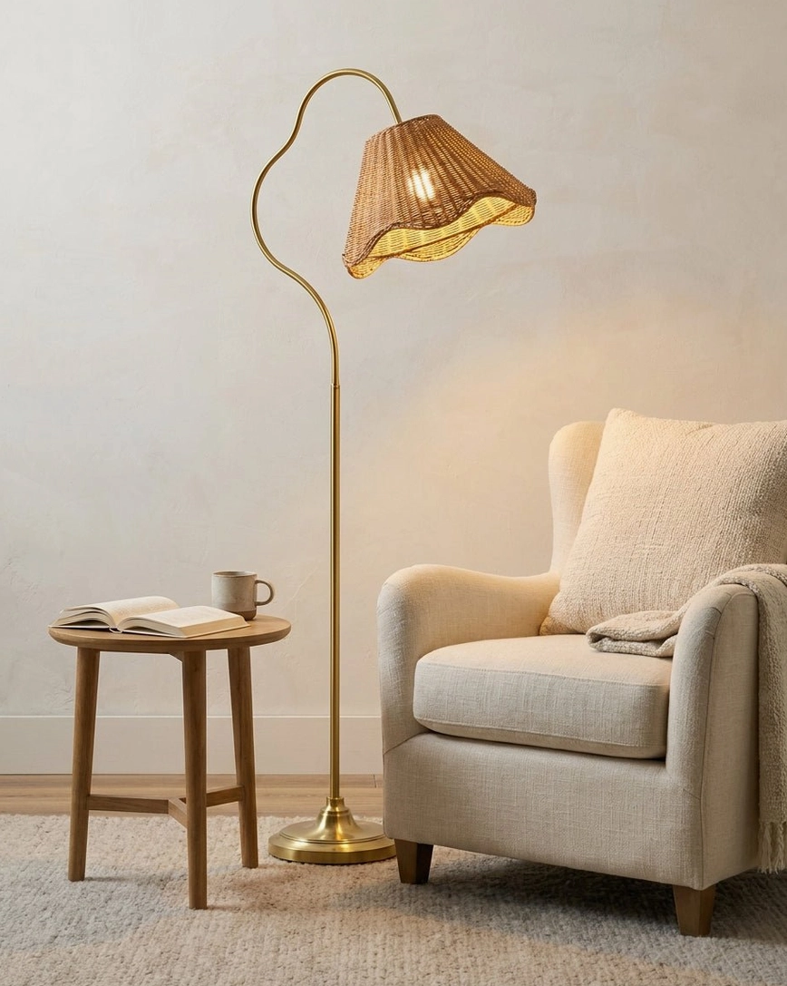 Curved metal arc floor lamp with hand-woven rattan shade beside minimalist upholstered armchair and side table