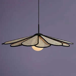 Modern bohemian rattan pendant lamp with woven shade and central milky glass bulb photographed on purple backdrop