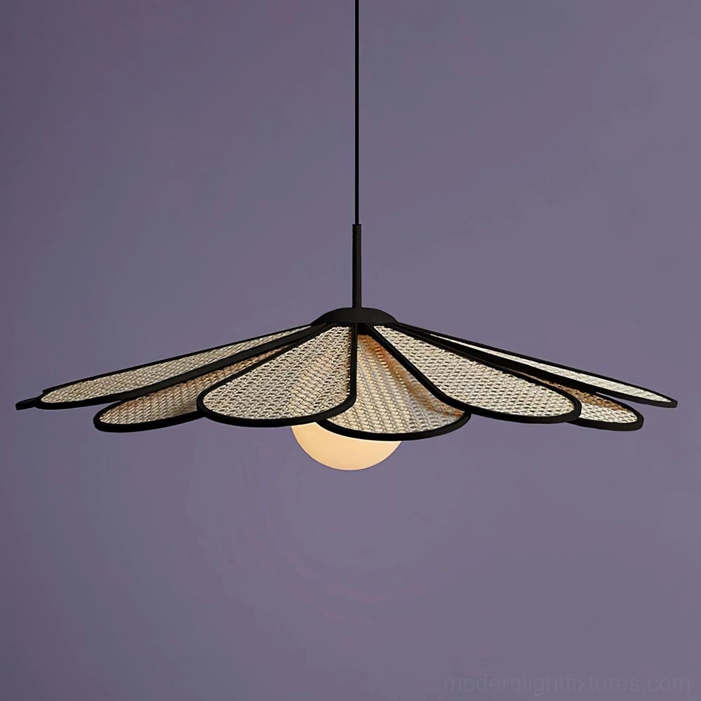 Modern bohemian rattan pendant lamp with woven shade and central milky glass bulb photographed on purple backdrop