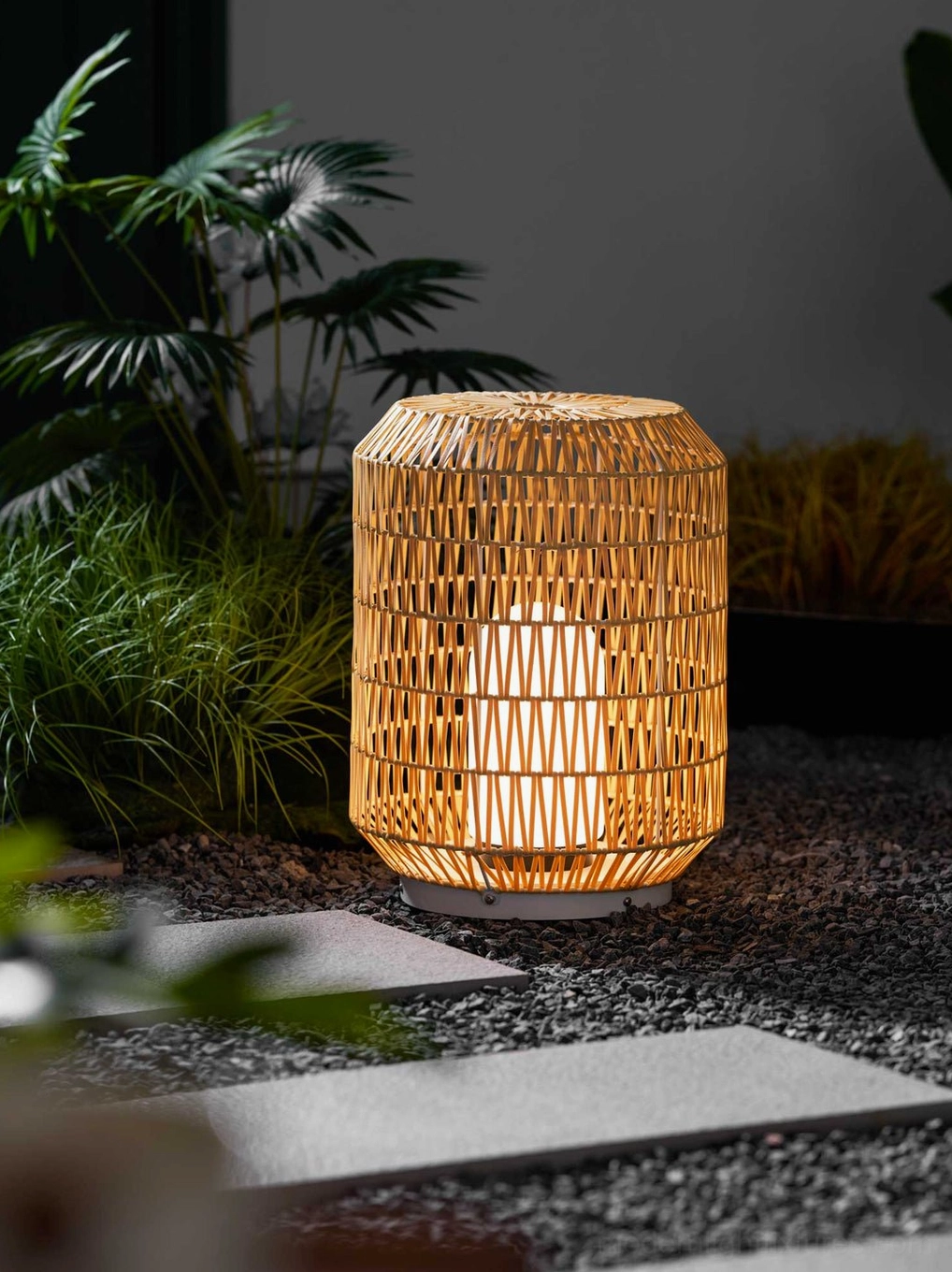 Multiple rattan outdoor lamps along garden pathway creating welcoming illuminated walkway