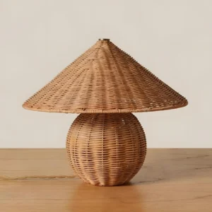 Natural rattan mushroom table lamp on wooden surface with exposed power cord, eye-level perspective showing soft filtered light through woven shade
