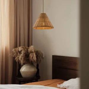 Rattan pendant lamp installed in warm bedroom interior, casting soft ambient light with dappled shadow patterns on walls