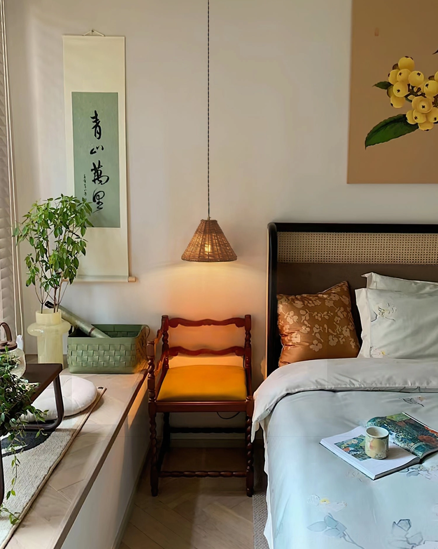 Rattan pendant fixture illuminating bedroom lounge area with Oriental boho decor and wooden furnishings