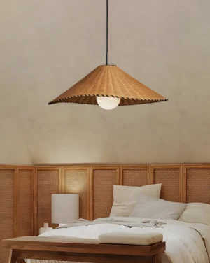 Textured rattan pendant light hanging in modern bedroom with wooden bed and woven headboard, warm ambient lighting