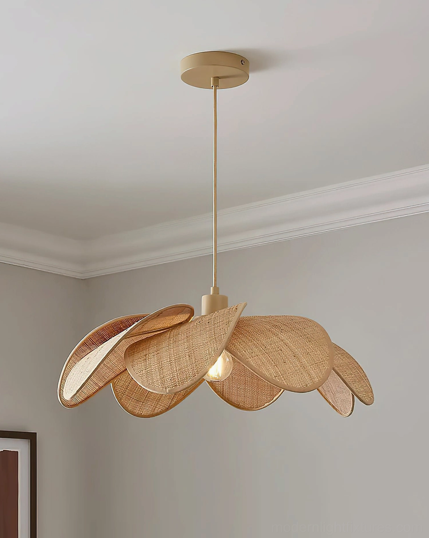 Handwoven rattan petal pendant lamp with gold accents displayed in grey minimalist bedroom setting