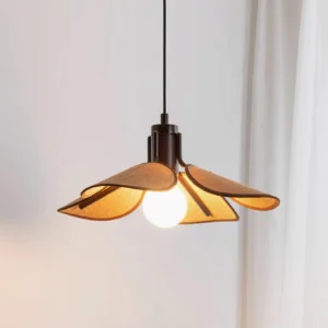 Modern boho rattan pendant light with petal-shaped shade, three-quarter front view against white curtain backdrop