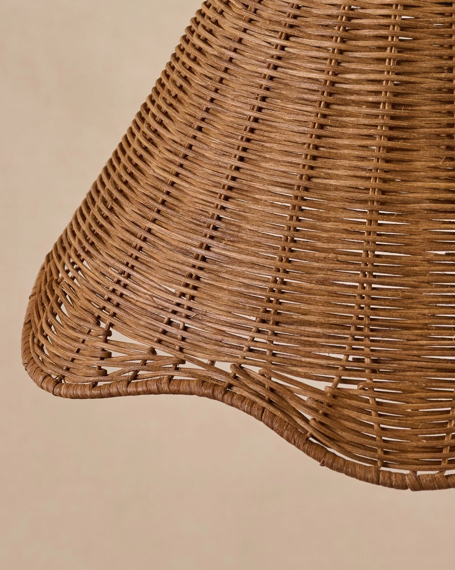 Hand-woven rattan pendant light in coastal Hamptons interior with warm gold hardware and natural materials