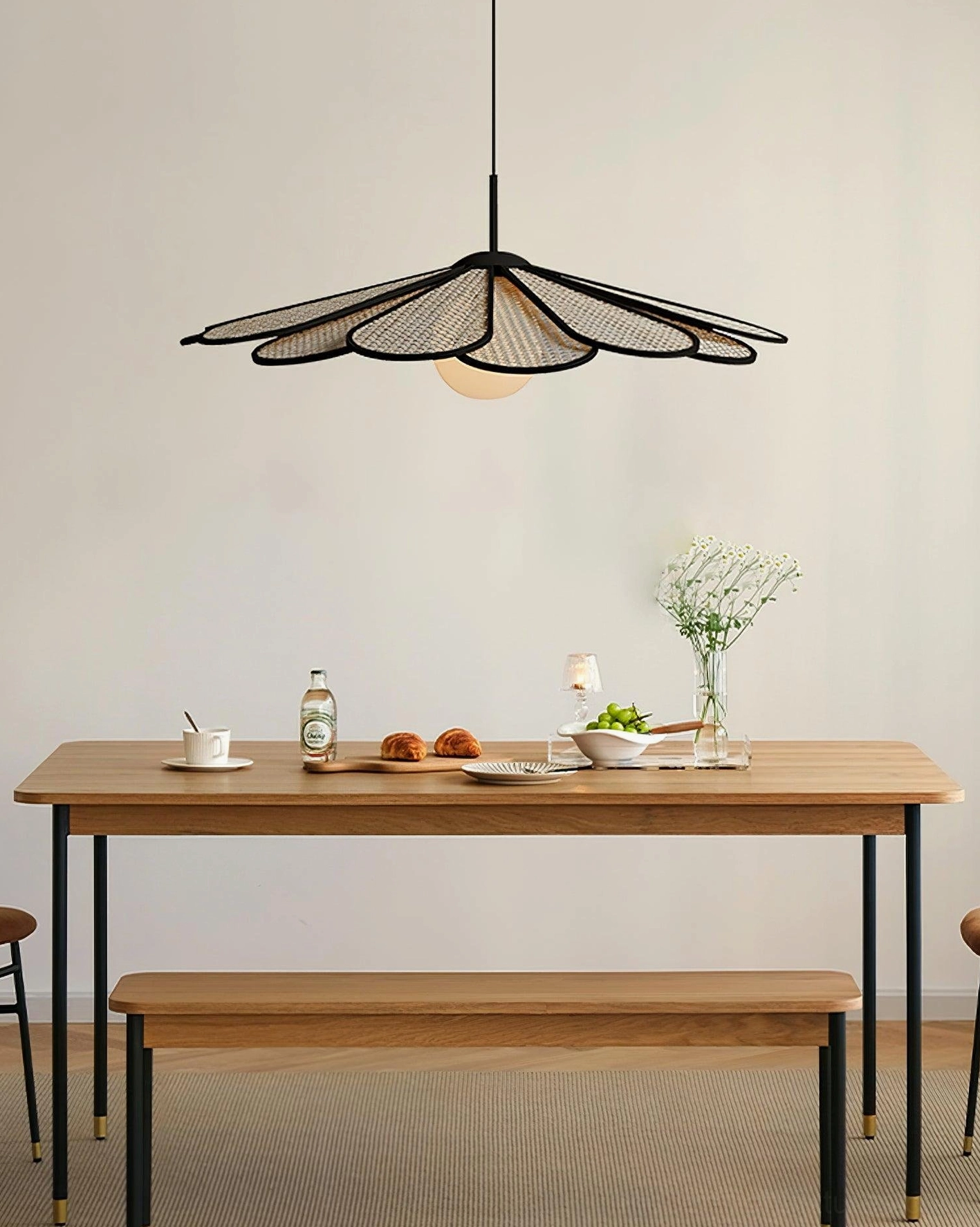Hanging rattan pendant fixture displaying flower-petal design illuminated with warm light in interior space