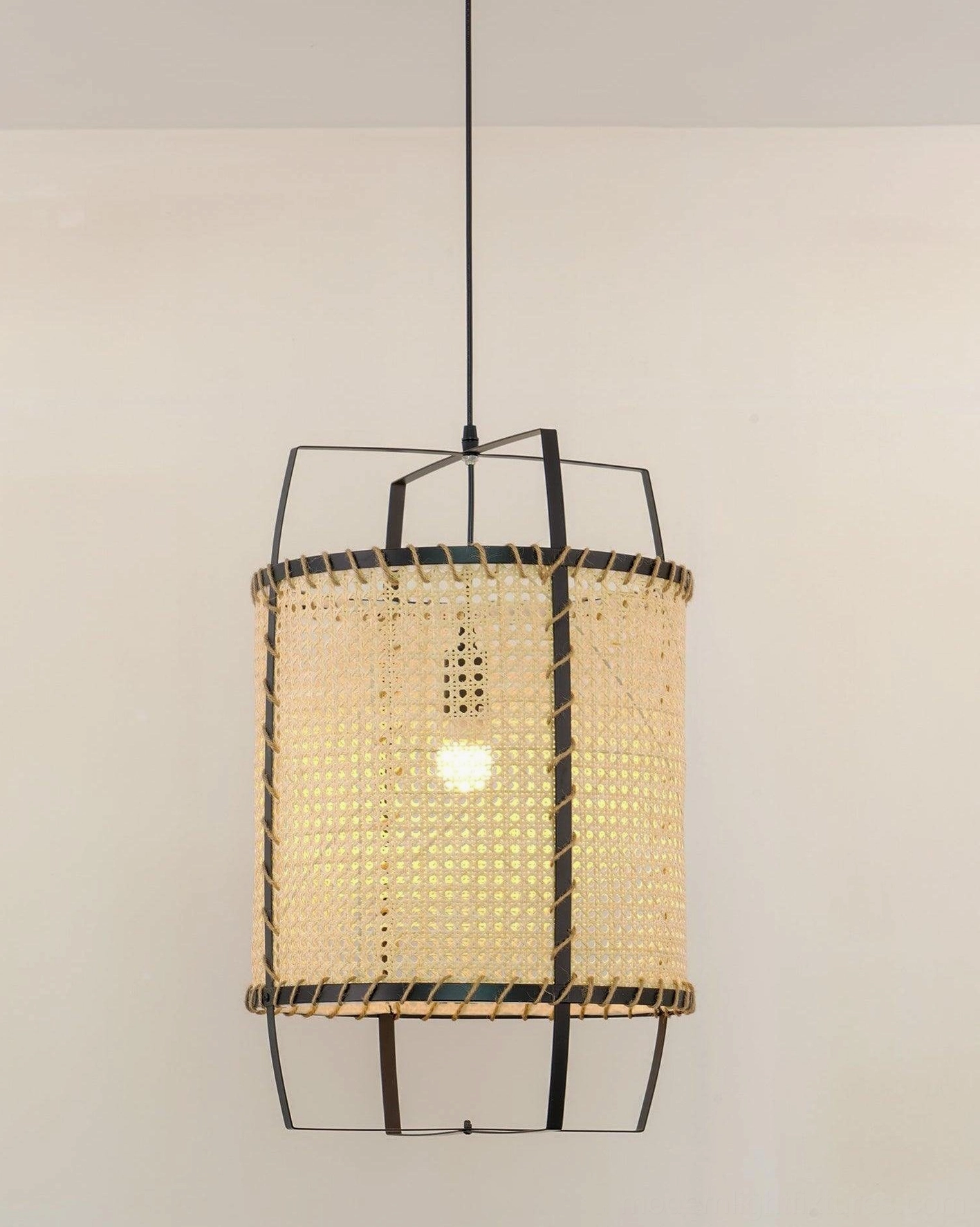 Black metal frame with rattan shade pendant light in modern minimalist home