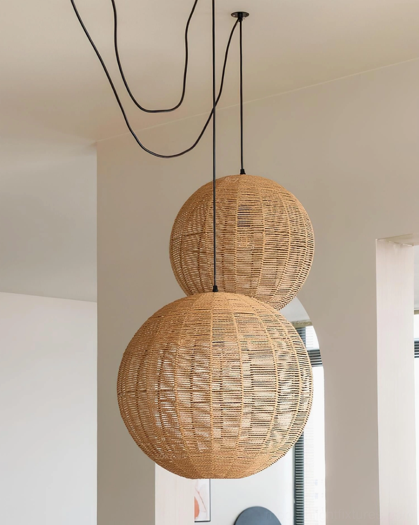 Woven rattan pendant lamp creating soft shadow patterns on wall and ceiling