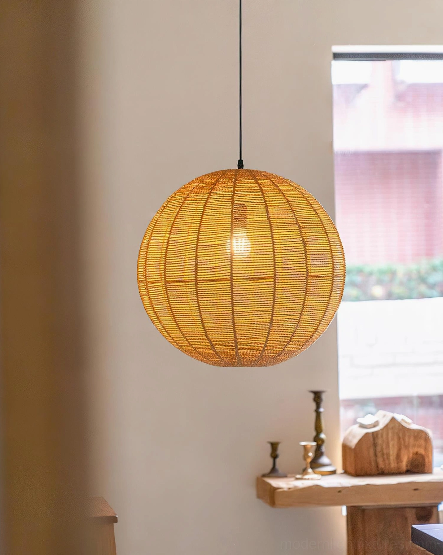 Illuminated rattan pendant light casting warm ambient glow in window corner setting