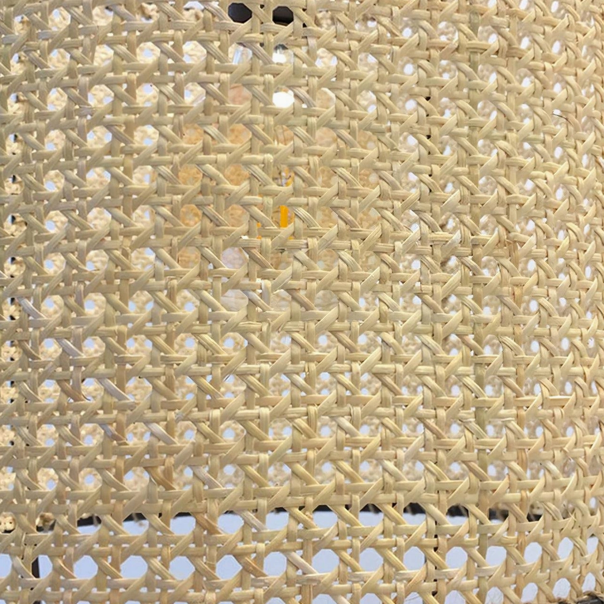 Warm glowing rattan pendant light creating inviting dining atmosphere